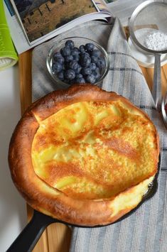 an omelet is sitting on a table with blueberries and other ingredients