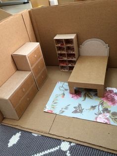 a cardboard doll house with furniture and boxes