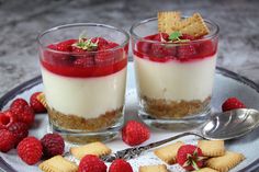 two desserts on a plate with raspberries and crackers