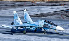 a fighter jet sitting on top of an airport tarmac