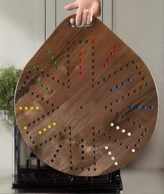 a person points at a board game on top of a stove in front of a potted plant