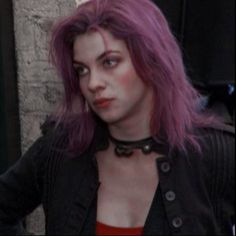 a woman with purple hair wearing a black jacket