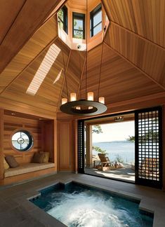 an indoor jacuzzi in the middle of a room next to a large window