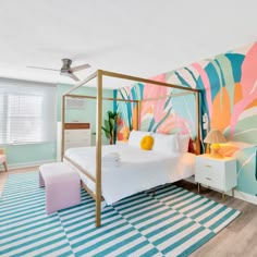 a bedroom decorated in pastel colors with a canopy bed and colorful rugs on the floor