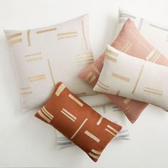 four decorative pillows on a white surface