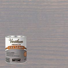 a can of paint sitting on top of a wooden floor