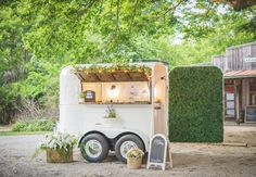 an ice cream truck parked in front of a building with plants growing out of it