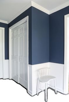 an empty room with blue walls and white trim on the walls, along with a chair