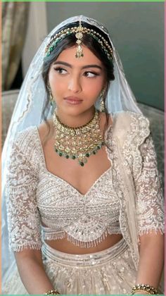 a woman wearing a bridal gown and jewelry