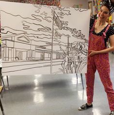 a woman standing in front of a drawing