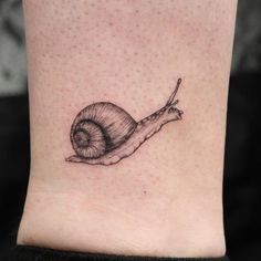 a small snail tattoo on the ankle