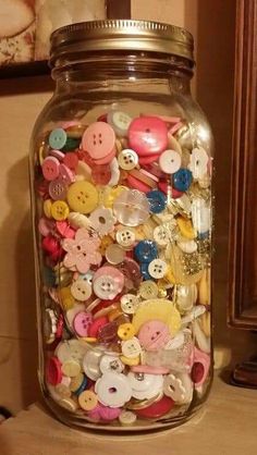 a jar filled with lots of different colored buttons