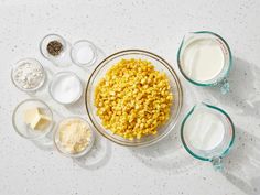 corn, milk, and other ingredients in bowls on a white counter top with speckles