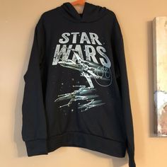 a black star wars sweatshirt hanging on a wall next to a framed painting and mirror