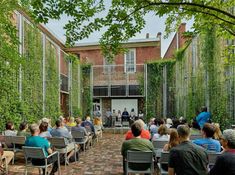 people are sitting in chairs and listening to an audience at the front of a building