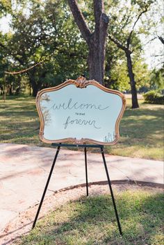 a welcome sign in front of a tree