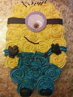 a cake made to look like a minion with yellow and blue icing on it