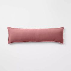 a pink pillow with fray edges on a white background