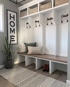 the entryway is decorated in white and wood with hooks on the coat rack, bench, and potted plant