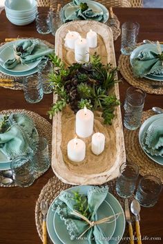 the table is set with candles, plates and place settings for dinner guests to enjoy