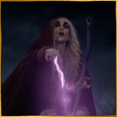 a woman dressed in costume holding a lightning stick