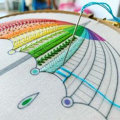 a close up of a colorful embroidery on a hoop