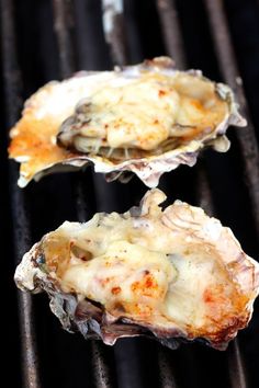 three oysters are being cooked on the grill