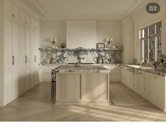 a large kitchen with marble counter tops and white cabinets