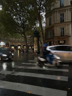 a city street with cars and people riding motorcycles