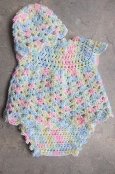 a crocheted baby bib laying on the ground