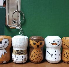 a row of painted wooden owls sitting on top of a table next to a wall