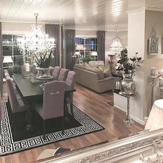 a formal dining room with chandelier and couches