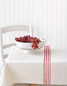 a bowl of grapes sitting on top of a table