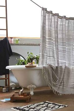 an old bathtub with a curtain hanging over it