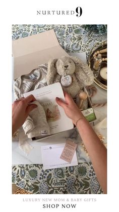 a woman is holding a baby's book in front of a box with stuffed animals