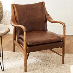 a brown leather chair sitting on top of a rug