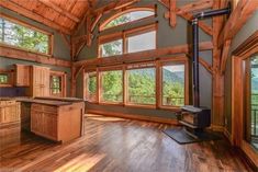 a kitchen with wood floors and large windows