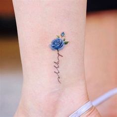 a blue rose tattoo on the ankle that says, love and is written in cursive writing