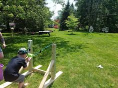 two men in the grass with buckets on their backs and one man holding a paintbrush