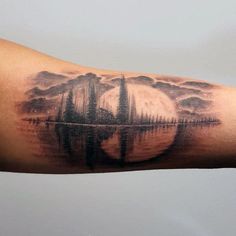 a man's arm with an image of a boat in the water on it