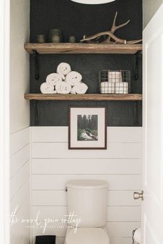 a white toilet sitting in a bathroom next to a wooden shelf