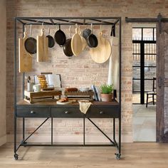 a kitchen with pots and pans hanging on the wall next to an iron table