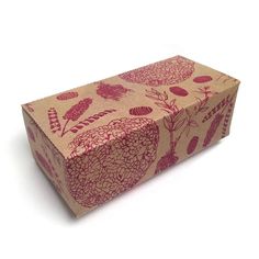 a brown box with red flowers and leaves printed on it, sitting on a white surface