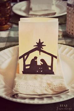 a nativity scene is displayed on a plate with napkins and place cards in front of it