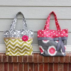 two purses sitting on top of a brick wall