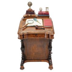 an old wooden desk with books on it and a pen in the drawer next to it