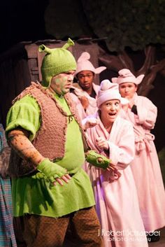 a group of people dressed in costumes on stage