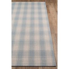 a blue and white checkered rug on a wooden floor