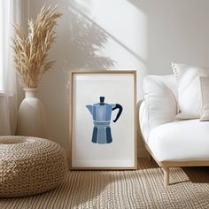 a blue coffee pot sitting on top of a table next to a white couch