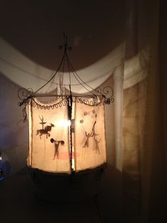 a lamp that is sitting on top of a table in front of a curtained window